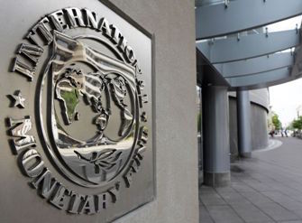 Pedestrians walk past the International Monetary Fund headquarters' complex in Washington Sunday, May 2, 2010. A senior International Monetary Fund official says the IMF's executive board is meeting in Washington to consider how much aid to grant Athens under a massive rescue loan package. (AP Photo/Cliff Owen)